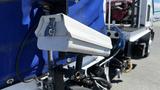 A close-up of a 2006 Ford LCF 550 featuring a rearview camera mounted on the vehicle's side with a visible blue tarp and various attachments in the foreground