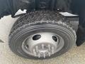 A close-up of a tire mounted on a 2021 Ford F-550 showcasing a rugged tread pattern and a silver wheel with lug nuts