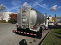 A 2013 Kenworth T370 truck with a silver fuel tank attached to the rear and dual exhaust pipes on the passenger side