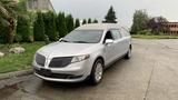 Silver 2013 Lincoln MKT hearse with a flat roof and chrome accents parked on a street