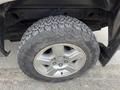 A close-up of a wheel from a 2013 Chevrolet Silverado Hybrid showing a rugged tread design and silver alloy rim