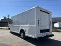 A white 2012 Ford Econoline van with a boxy cargo area and large rear doors is shown from the back angle