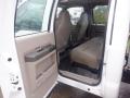 Interior of a 2009 Ford F-450 SD featuring two front seats and a rear bench seat upholstered in beige fabric