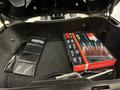 A black storage compartment containing an air filter box and a black pouch with the BMW logo