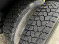 Close-up of the treads on two large tires of a 2008 Ford F-750 showing deep grooves for traction and slightly worn surfaces with some debris visible in the tread