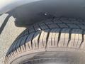 Close-up of a worn tire from a 2017 Chevrolet Express showing tread wear patterns and visible cracks in the rubber