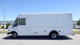 A white 2006 Ford Econoline box truck with a flat front and large side windows parked on a lot