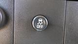 A black button labeled OFF with a car icon and a traction control symbol on a dashboard