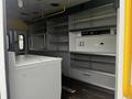 Interior of a 2016 Chevrolet Express with shelving units and a metal counter space designed for utility use