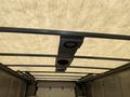 A 2012 Ford Econoline with a spacious cargo area featuring a metal frame and a light-colored fabric ceiling