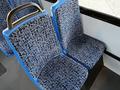 Two blue and black patterned seats with a rounded handle on one side in a vehicle interior