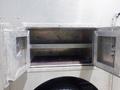 An open metal storage compartment of a 2007 Morgan Olson Workhorse W42 showing two shelves inside