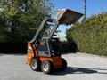 A 2017 Gehl R105 skid steer loader with an elevated front bucket and distinct orange and gray coloring