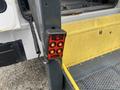 A control panel with four buttons mounted on a support beam next to the open door of a 2017 Chevrolet Express