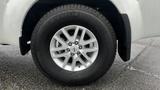 A close-up view of a silver alloy wheel of a 2016 Nissan Frontier featuring a modern design and a Michelin tire