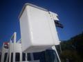 A white bucket truck with a raised bucket for elevated work on the top of the vehicle