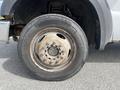 A close-up of a rusted wheel on a 2010 Ford F-550 showcasing the tire tread and metal rim details