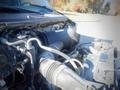 A close-up view of the engine compartment of a 2006 Ford F-650 showing various components and hoses