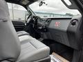 Interior view of a 2011 Ford F-250 SD showing grey seats and dashboard with a no smoking sign on the dashboard and various controls and knobs