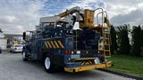 A 2009 International 4300 utility truck with a bucket lift and various equipment mounted on the back in blue and yellow colors