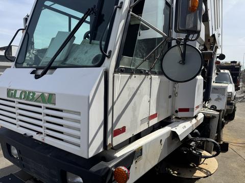 A 2015 Global Street Sweeper with a white and green exterior featuring a large front windshield and a side mirror