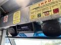 A dashboard of a 2011 Ford Econoline featuring a car stereo and two speakers mounted above the controls with various warning and instruction signs around