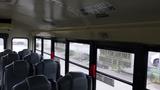 Interior of a 2015 International PC105 school bus showing rows of gray seats and emergency exit signs on the windows