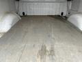 Interior of a 2010 Ford F-150 truck bed showing a wooden floor with signs of wear and some dirt