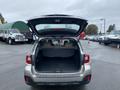 A 2019 Subaru Outback with the rear hatch open showing the spacious cargo area and beige interior trim