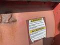 Close-up of a caution warning label attached to the front of a 2010 Ford F-550 indicating precautions for operating the vehicle with a blade assembly