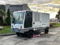 2007 Tennant Sentinel street cleaning vehicle with a gray and white exterior featuring a large front windshield and a broom attachment at the front