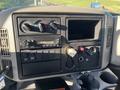 Dashboard of a 2013 International 4300 featuring climate controls a radio and various gauges and buttons