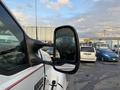 Close-up of the side mirror of a white 2006 Ford F-650 with a red stripe on the cab