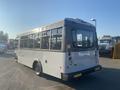 A white 2017 Chevrolet Express shuttle bus with large windows and a sleek design parked with its back facing the viewer