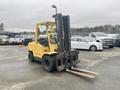 A yellow 2000 Hyster 120 forklift with a raised mast and two fork arms in front