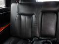 Interior of a 2008 Cadillac Limousine featuring black leather upholstery and a sleek design with wooden accents