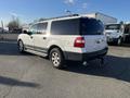 A silver 2013 Ford Expedition with a rear view showing its sturdy build and large tires