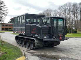 A 2023 Prinoth Panther T6 all-terrain vehicle with a large cabin, rubber tracks, and a rear-mounted winch designed for various demanding terrains