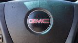 Close-up of the GMC logo on the steering wheel of a 2012 GMC Savana