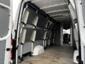 Interior of a 2016 Mercedes-Benz Sprinter with metal shelving units mounted on the walls and an empty floor space visible