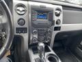 Interior dashboard of a 2014 Ford F-150 featuring a radio display climate controls and gear shift lever