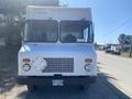 A white 2008 Ford Econoline van with a large front windshield and a prominent grille visible in the foreground