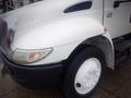 A white 2006 International 4300 truck with a rounded hood and large wheel well visible in the foreground