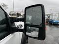 A 2014 Ford F-550 side mirror with raindrops on the surface