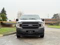 A 2018 Ford F-150 facing forward with a silver front grille and black lower bumper