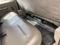Interior of a 2010 Ford F-550 showing a rear bench seat with gray fabric upholstery and a rubber floor mat