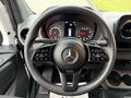 Steering wheel of a 2019 Mercedes-Benz Sprinter with controls and dashboard gauges visible in the background