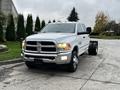 A 2018 RAM 3500 pickup truck with a white exterior and chrome accents parked on a driveway facing forward with a clear cab and dual rear wheels