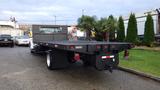 A black 2008 Ford F-650 flatbed truck with a textured loading surface and a rear view featuring red and white reflective marks