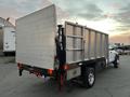 A white 2008 Dodge Ram 5500 with a silver dump bed viewed from the rear showcasing its flatbed and tail lights